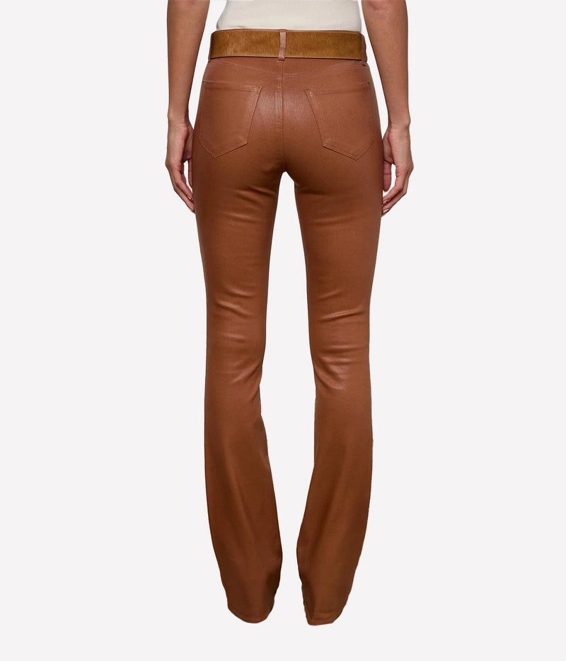 A back view of a model wearing the L'AGENCE Selma Coated Bootcut Jean in Cognac and a white top with a tan belt
