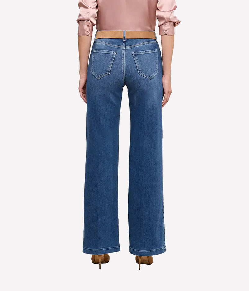 A model shown from the back wearing the L'AGENCE Scottie Wide-Leg Denim Jean in Cambridge, a light pink blouse, and brown heels.