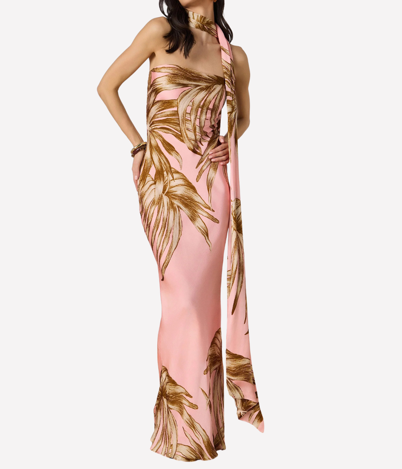 Woman wearing a pink and gold floral dress on a white background