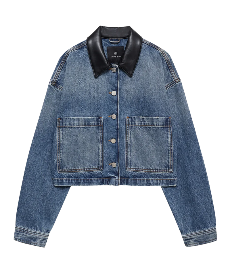 A cropped blue denim jacket with a black leather collar, featuring two front patch pockets and button closures, shown flat on a white background.