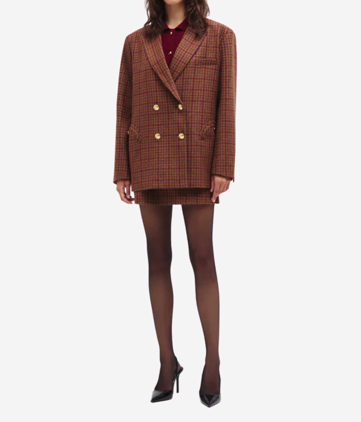 A model wearing the Blazé Milano Sweet Sea Nightbreak Blazer in Cinnamon Mix, paired with a matching mini skirt, sheer black tights, and black high heels