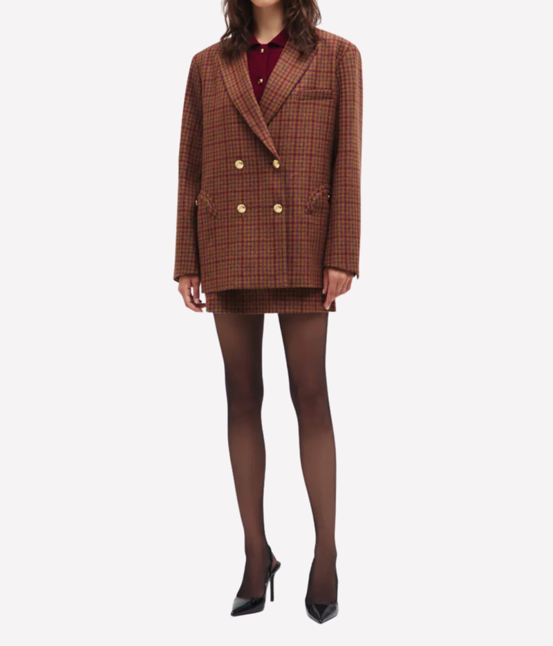 A model wearing the Blazé Milano Sweet Sea Nightbreak Blazer in Cinnamon Mix, paired with a matching mini skirt, sheer black tights, and black high heels