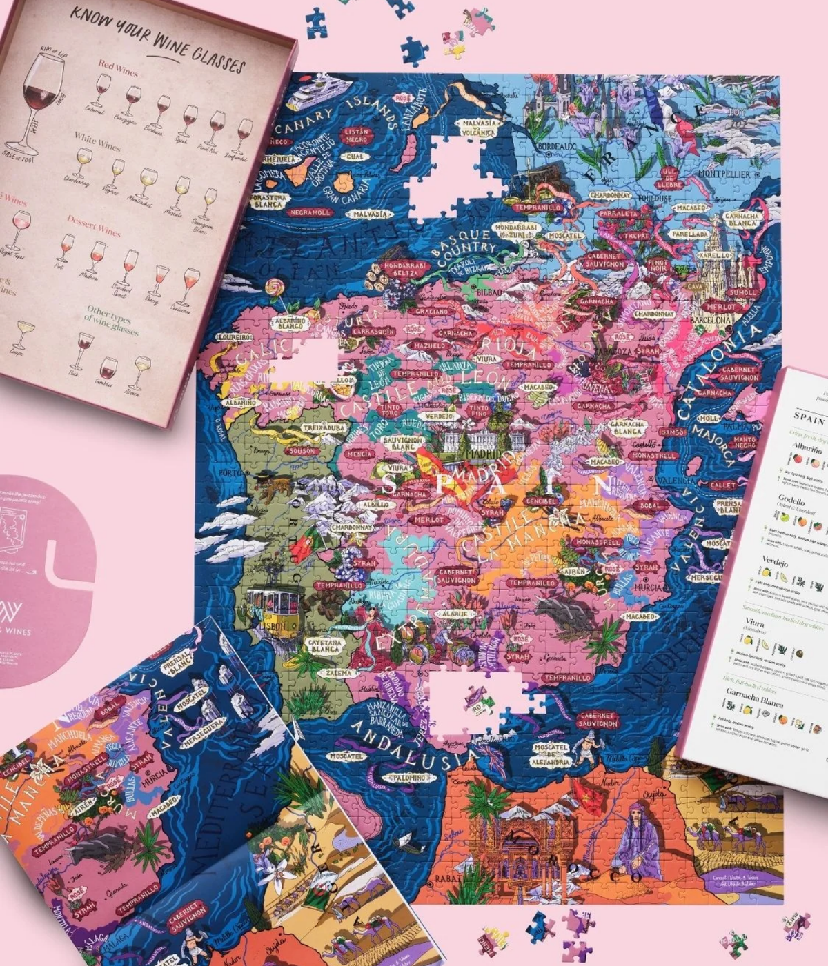 Water and Wines 1000 Piece Puzzle of Spain nearly complete and laid flat beside the open box lid with its wine glass guide, the grape profile card, the box stand and the fold-out poster