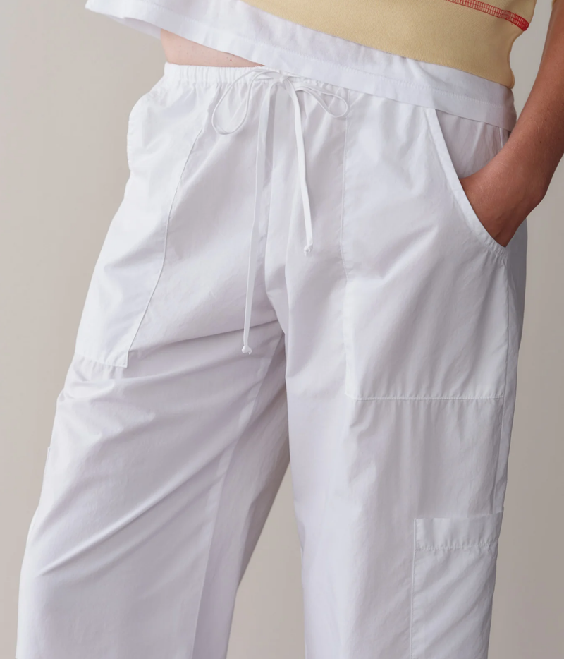 Close-up of the DONNI. The Pop Drawstring Cargo Pant in Powder showing the tie drawstring, elastic waistband, slant pocket and panelled patch pockets
