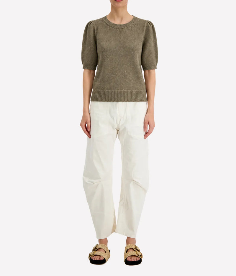 Front view of a model wearing the Avant Toi Cashmere Short Sleeve in Mushroom tucked into cream barrel-leg trousers with dark sandals, showing the crew neckline and puff sleeves