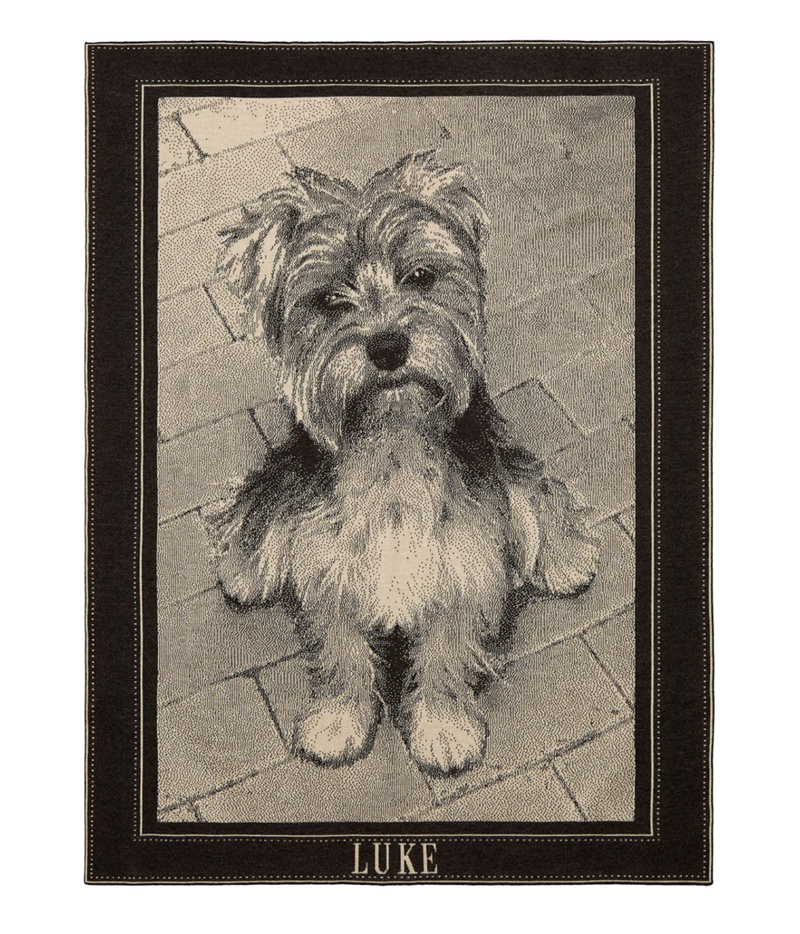 A rectangular blanket featuring a detailed portrait of a dog, framed by a dark border with the name 'LUKE' at the bottom