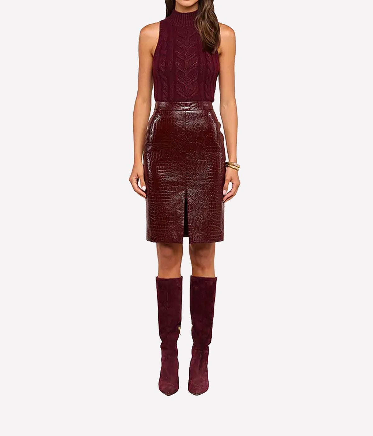 A model wearing a sleeveless high-neck burgundy knit top and a matching textured croc-embossed vegan leather skirt, paired with matching burgundy over-the-knee boots.