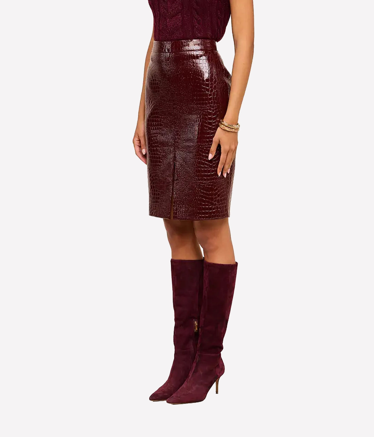 A model wearing a dark burgundy croc vegan leather pencil skirt paired with matching burgundy knee-high suede boots
