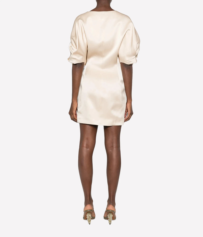 Back view of a model wearing the Raquel Diniz Anastasia Short Dress in Vanilla with strappy heeled sandals, showing the puffed sleeves and fitted mini silhouette