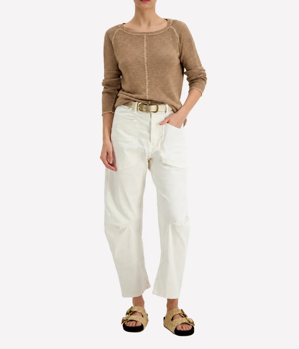 Model wearing the Avant Toi Maglia Pullover in Sughero tucked into cream barrel-leg trousers with a brown leather belt and dark sandals