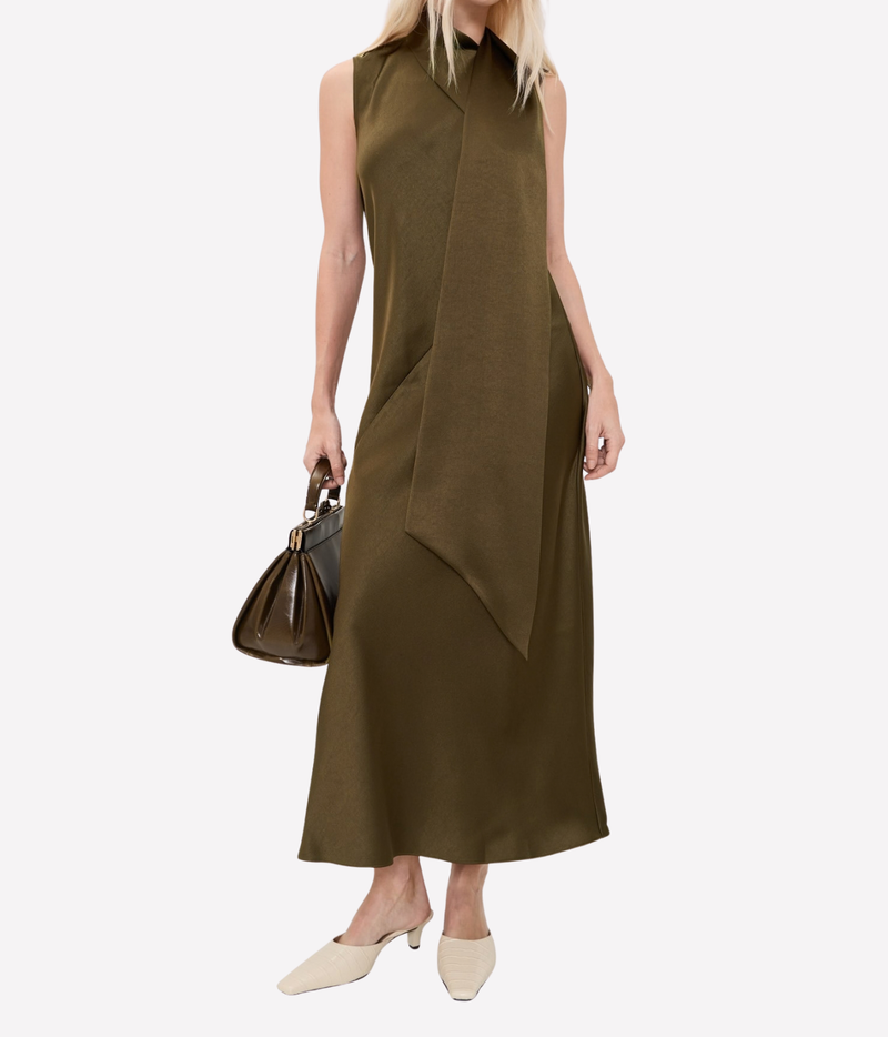 Model wearing the Vince Draped Scarf Tie Dress In Cypress holding a black leather handbag, with cream flats