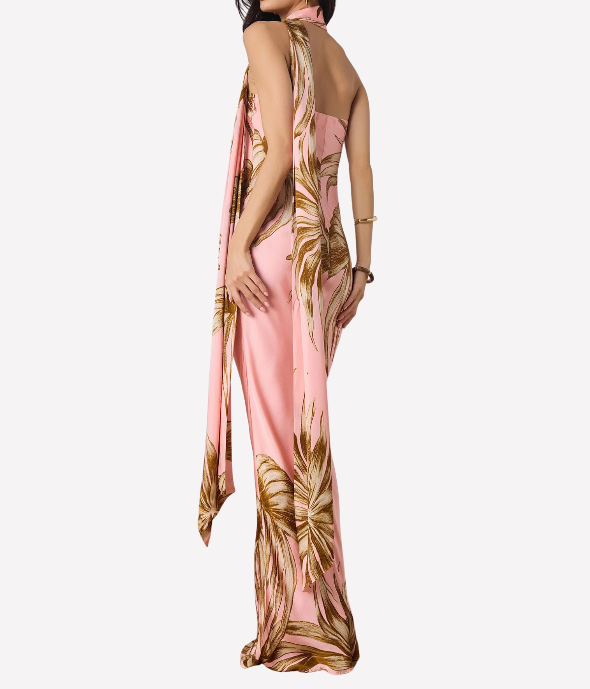 Woman wearing a pink and gold patterned dress on a white background