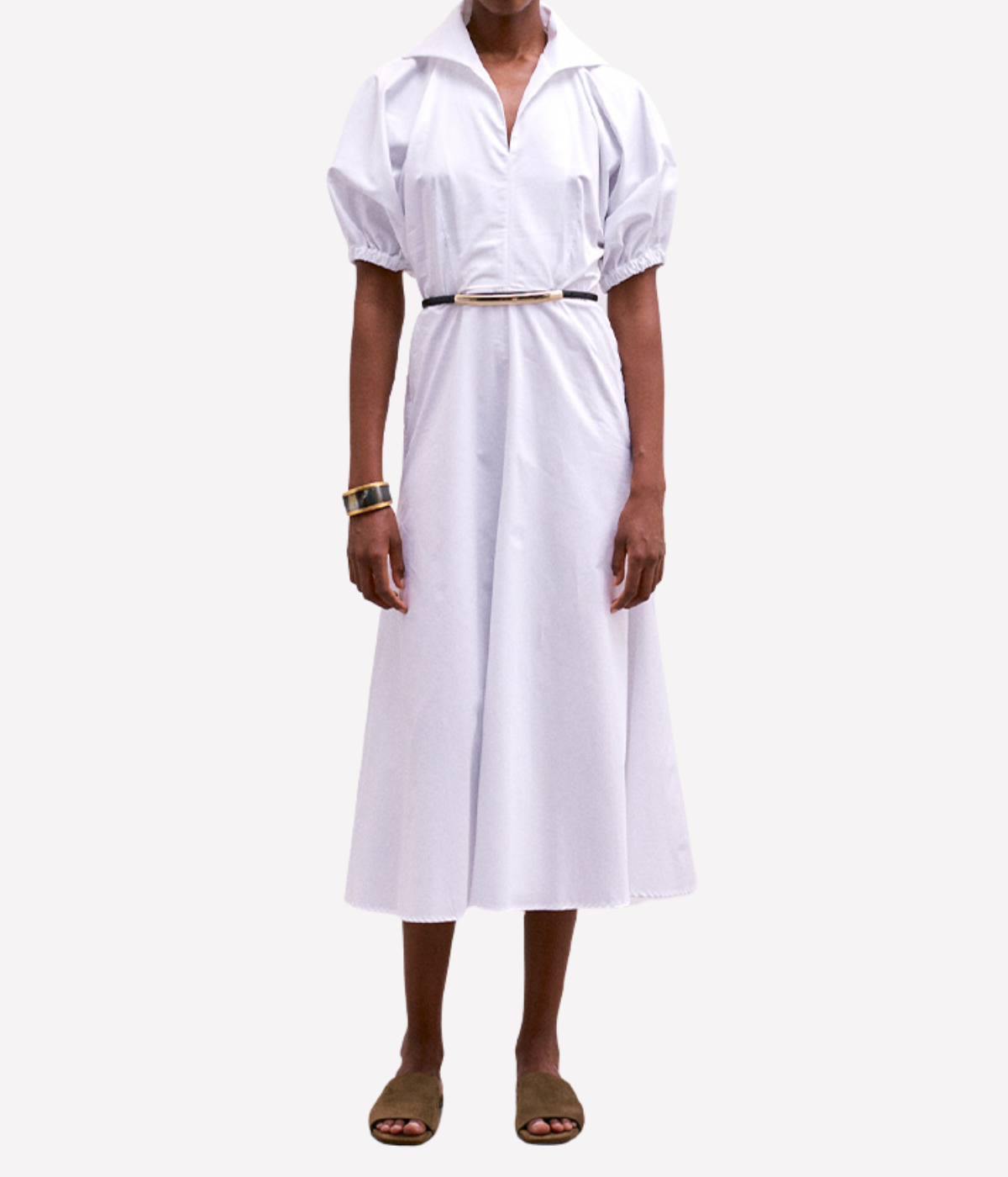 Person wearing a white dress with a belt on a white background