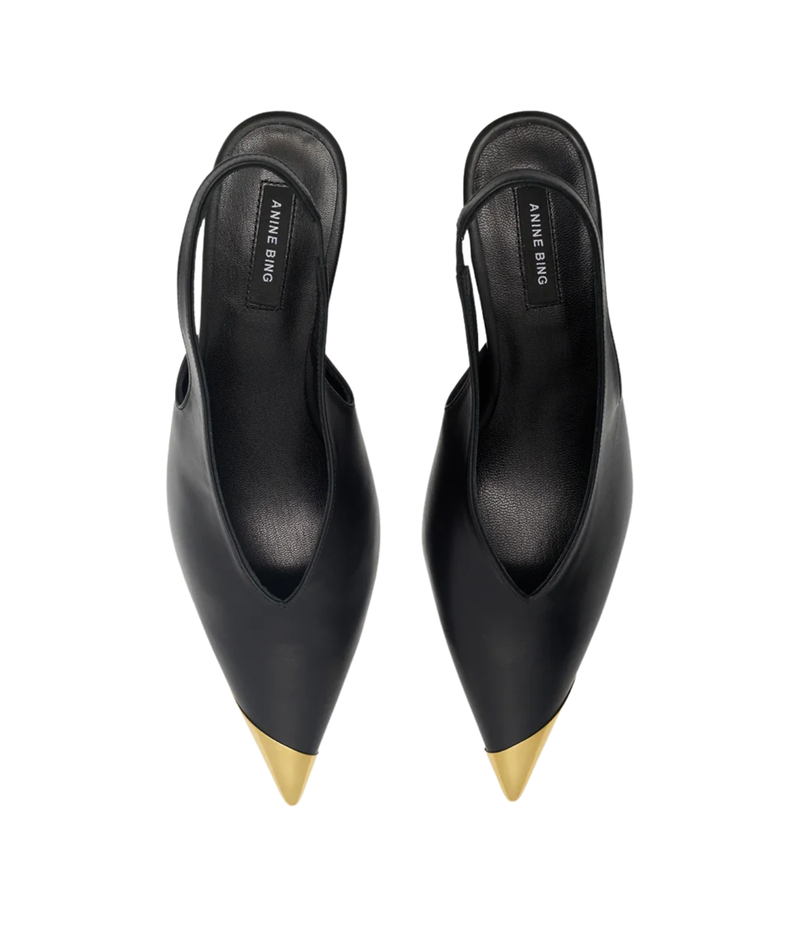 Pair of Anine Bing Nelly Slingback Metal Toe in Black viewed from above, showing the deep V-cut vamp, pointed gold metal toe caps and slingback straps