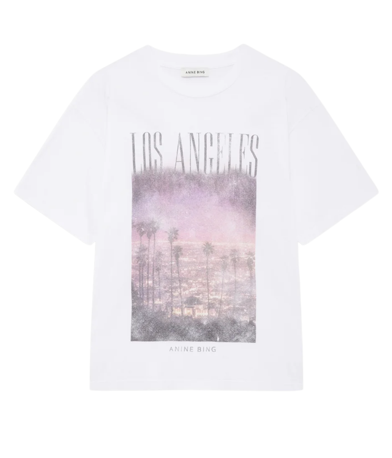 Anine Bing Cade Tee Los Angeles In White laid flat, showing the crew neckline, short sleeves and LOS ANGELES lettering above a pink-toned palm tree photo print