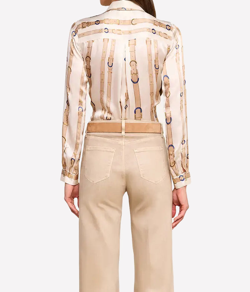 A model shown from the back wearing a beige and cream silk shirt with a gold chain print, paired with beige trousers and a matching belt.