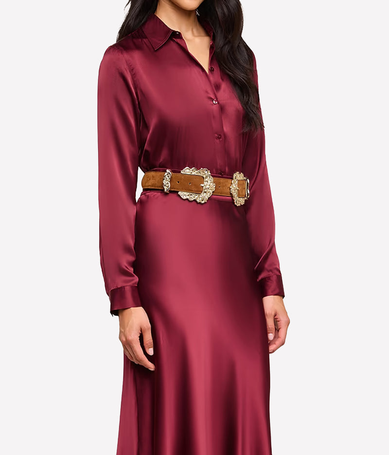 A front side on image woman wearing the L'AGENCE Tyler Silk Blouse in Merlot Red, styled with a brown suede belt and matching silk maxi skirt in red
