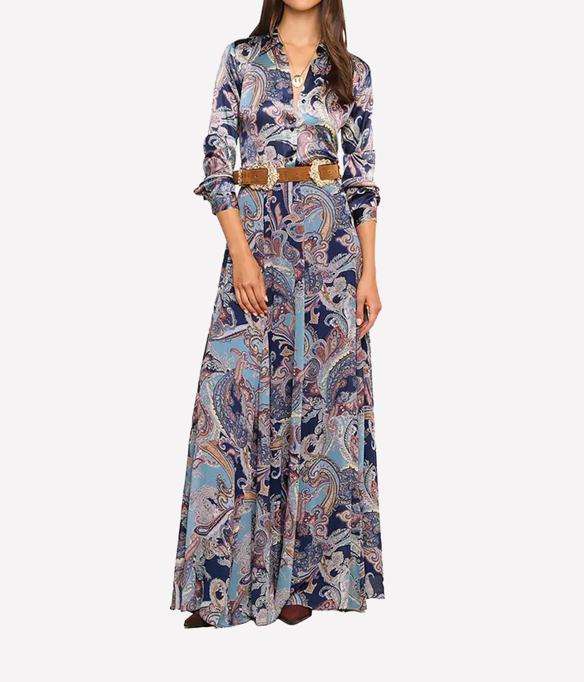 A woman models a long-sleeved shirt with a blue, beige, and white paisley pattern, styled with a brown belt.