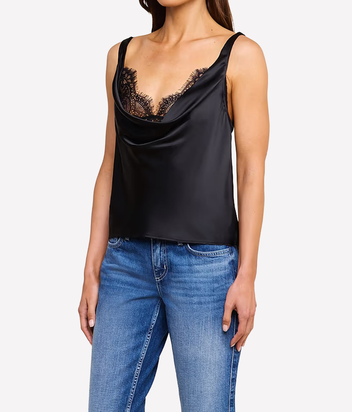 A woman wearing the L'AGENCE Evadne Silk Lace Camisole in Black with black lace bust detailing, paired with blue jeans.