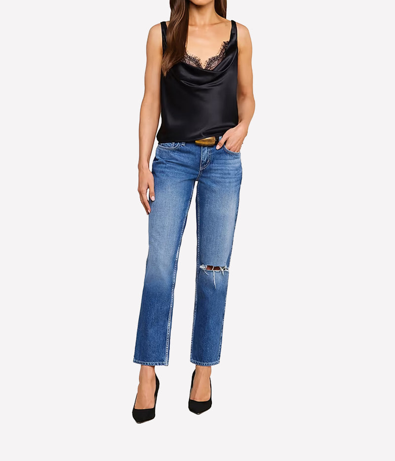 A model wearing the L'AGENCE Evadne Silk Lace Camisole in Black, blue cropped jeans and black heels.