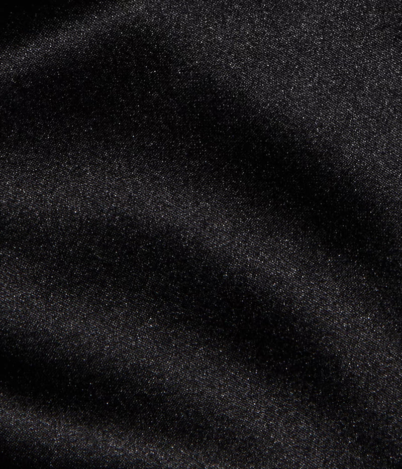 A close-up of the L'AGENCE Evadne Silk Lace Camisole in Black with its silk fabric showing soft folds and shadows. 