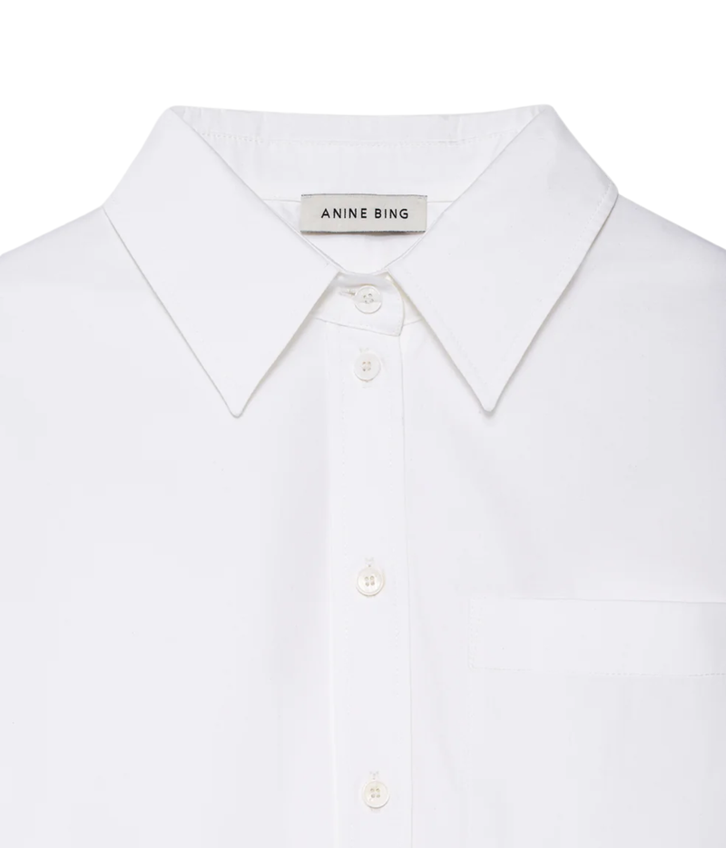 Close-up of a white Anine Bing button-down shirt collar with a visible brand label on the inner neck.