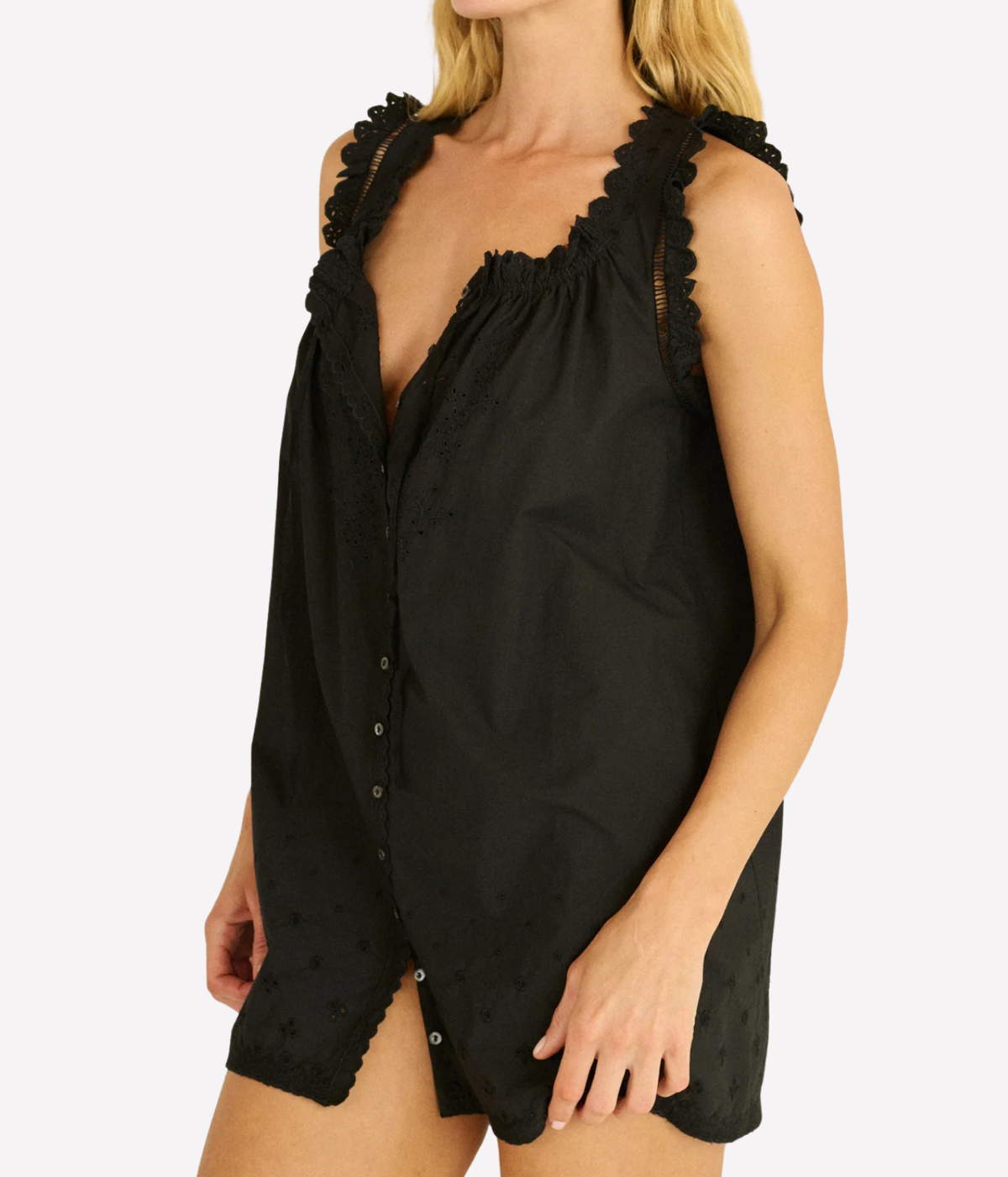 Close-up of a model wearing the DÔEN Nessie Dress in Black unbuttoned at the neckline, showing the ruffled shoulder straps and button-through front