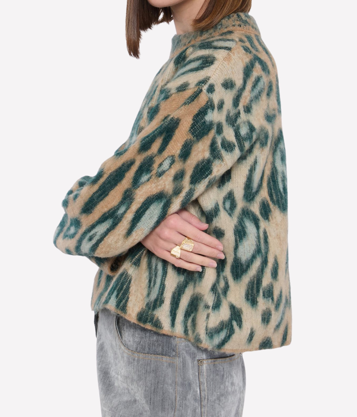 Side profile of a model wearing the forte forte Brit Leopard Jacquard Gauzed Alpaca Sweater in Woods with a hand on her hip and gold rings, showing the relaxed shape and hip-length hem