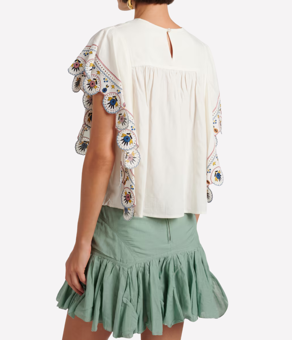 A woman shown from the back wearing a cream-coloured blouse with colourful floral embroidered ruffle sleeves - Marlie Top In Ecru