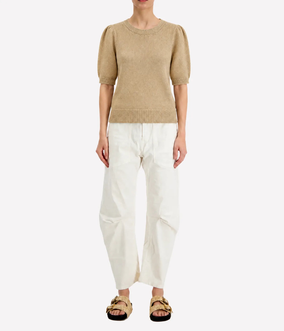 Front view of a model wearing the Avant Toi Cashmere Short Sleeve in Burro tucked into cream barrel-leg trousers with dark sandals, showing the crew neckline and puff sleeves
