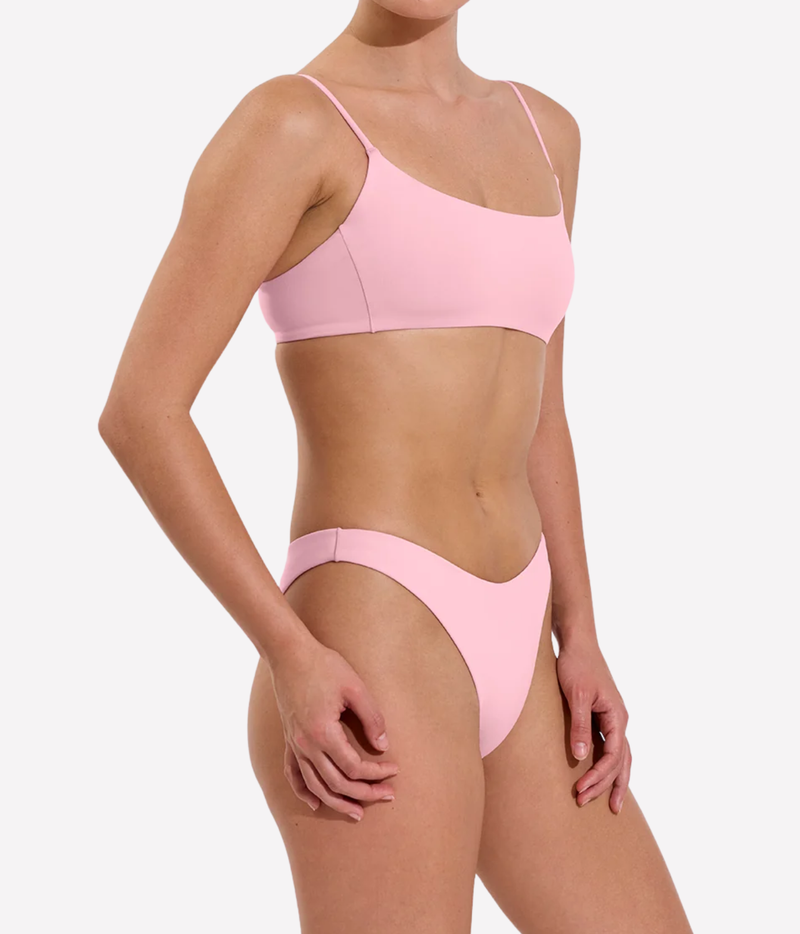 A model wearing a light pink two-piece bikini set, featuring a scoop-neck bikini top with thin straps and matching high-cut bikini bottoms, Left On Friday, Dip Bottom In Delight