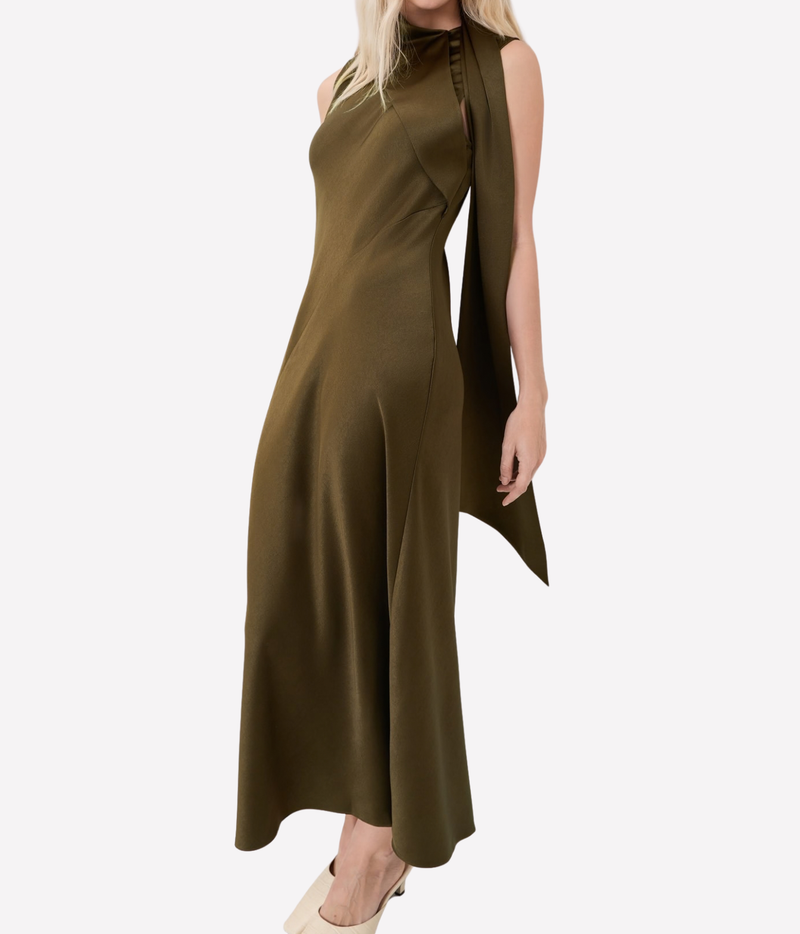 Side profile of a model wearing the Vince Draped Scarf Tie Dress In Cypress, showing the scarf tie trailing down the back and the fluid maxi length