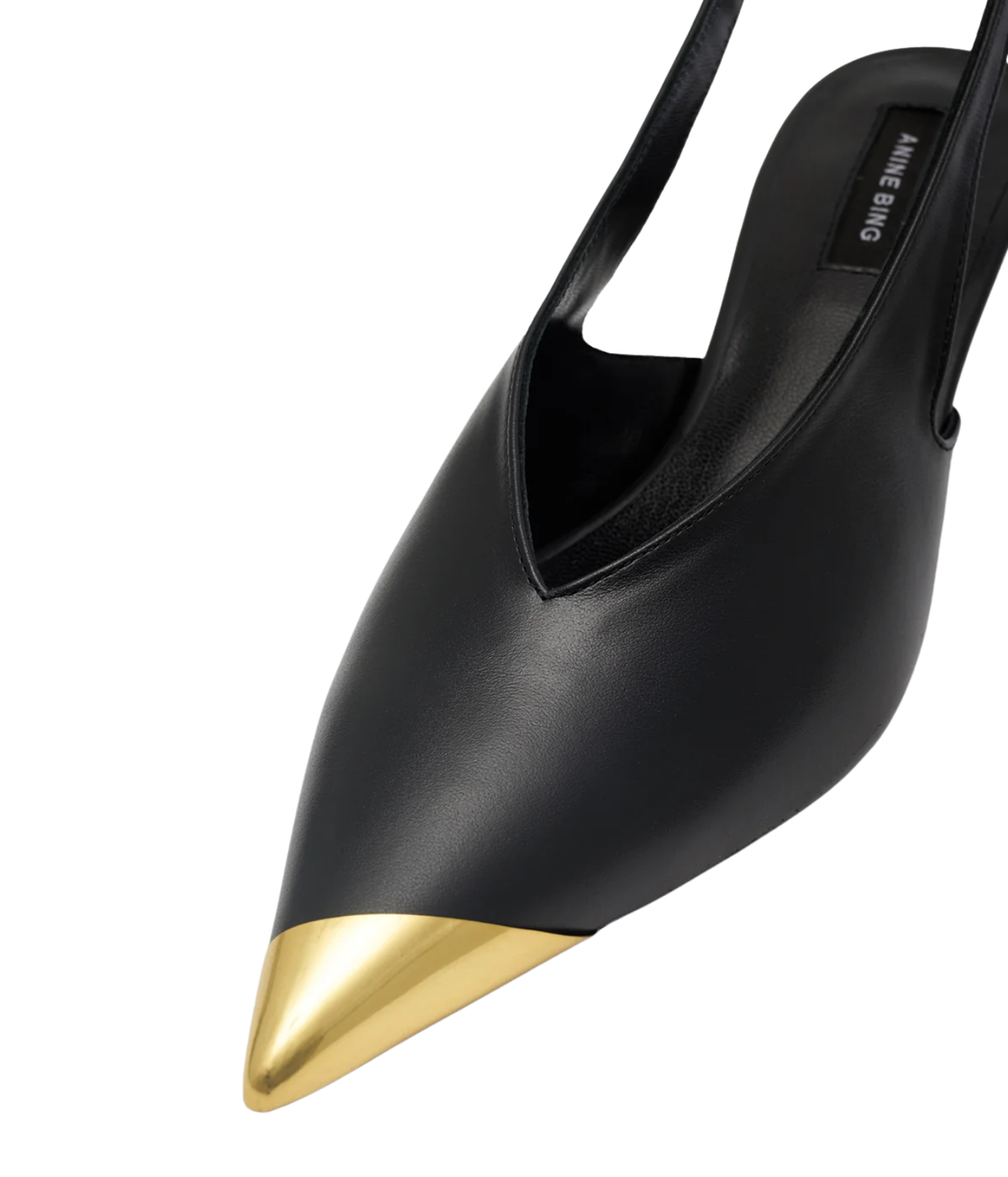 Close-up of the Anine Bing Nelly Slingback Metal Toe in Black, showing the polished gold metal toe cap and the V-shaped leather vamp