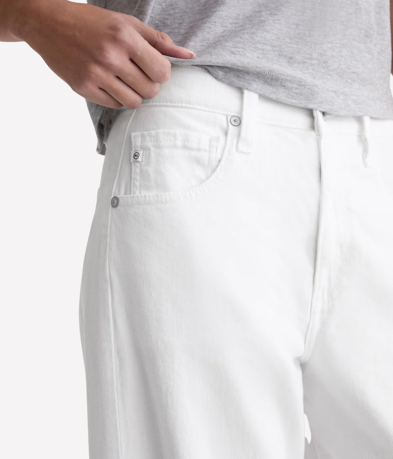 Close-up of a person wearing white denim jeans, showing the back pocket, button, waistband, and part of a light gray heathered t-shirt.