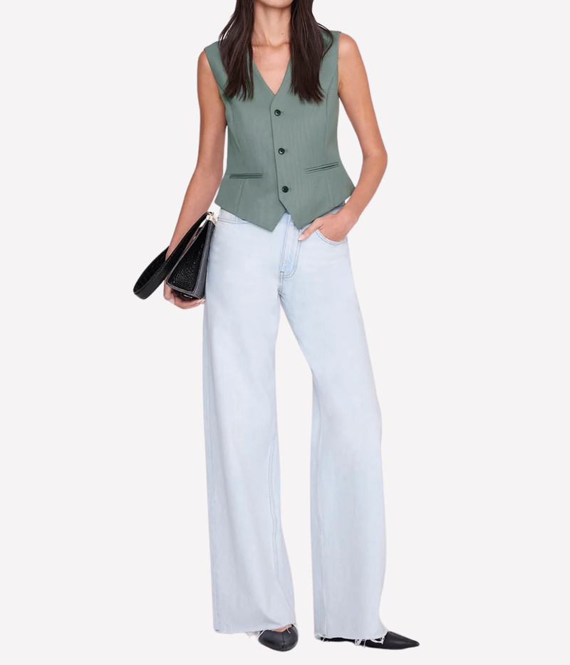 Model wearing the Anine Bing Mario Vest in Sage buttoned with light-wash wide-leg jeans, black pointed shoes and a black leather bag