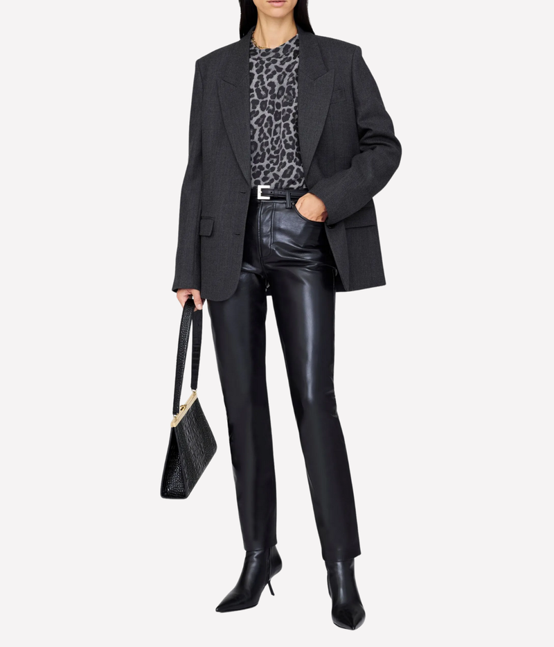 Person wearing a black blazer, leopard print top, black leather pants, and black boots on a white background.