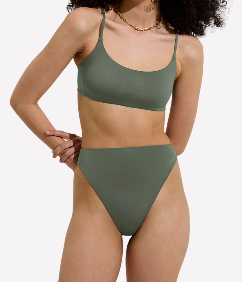A woman modeling a two-piece bikini set in a muted sage green color, featuring the Left On Friday Pool Days Top in Agave – front view