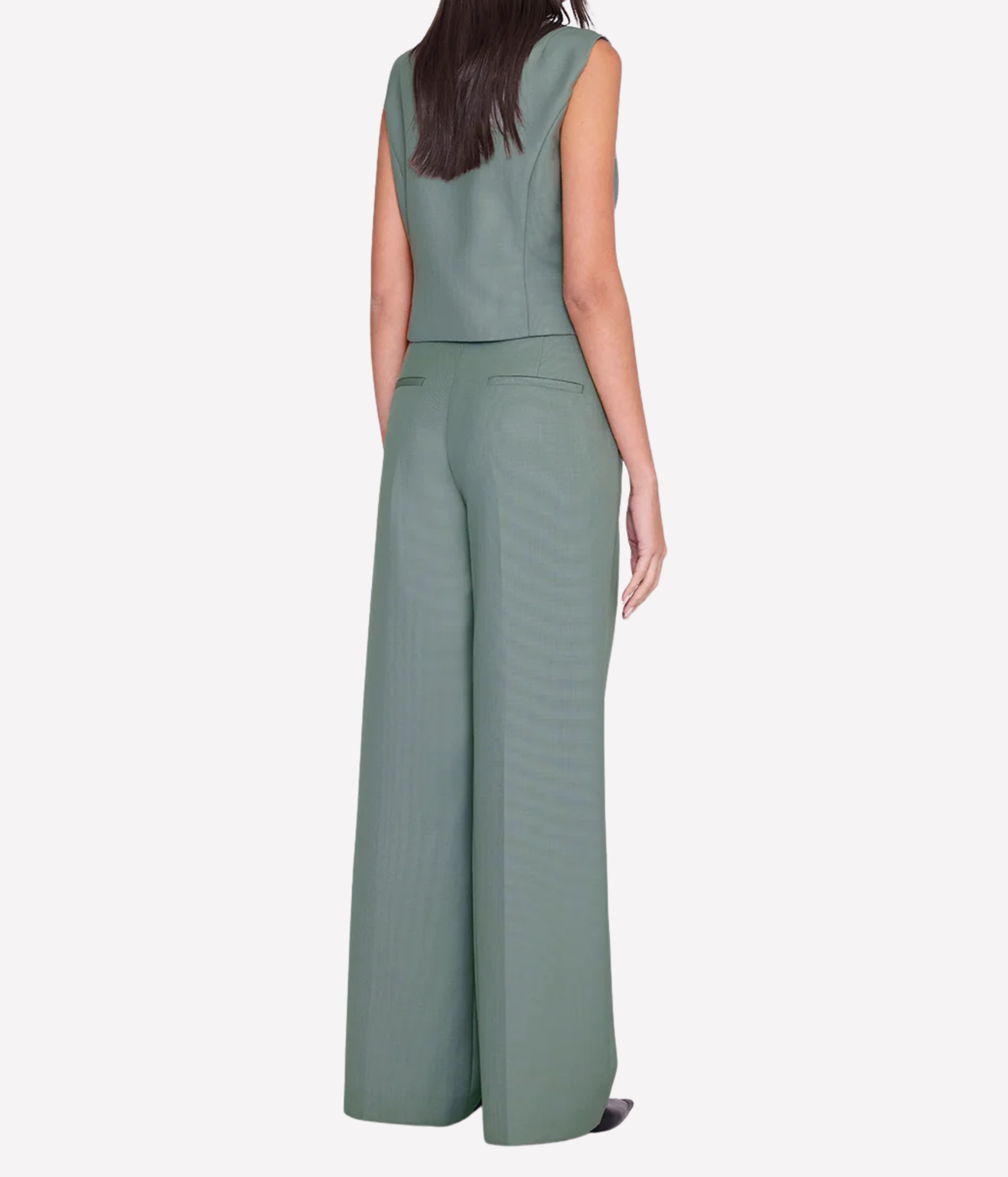 Back view of a model wearing the Anine Bing Mario Vest in Sage with matching sage wide-leg trousers, showing the fitted shape