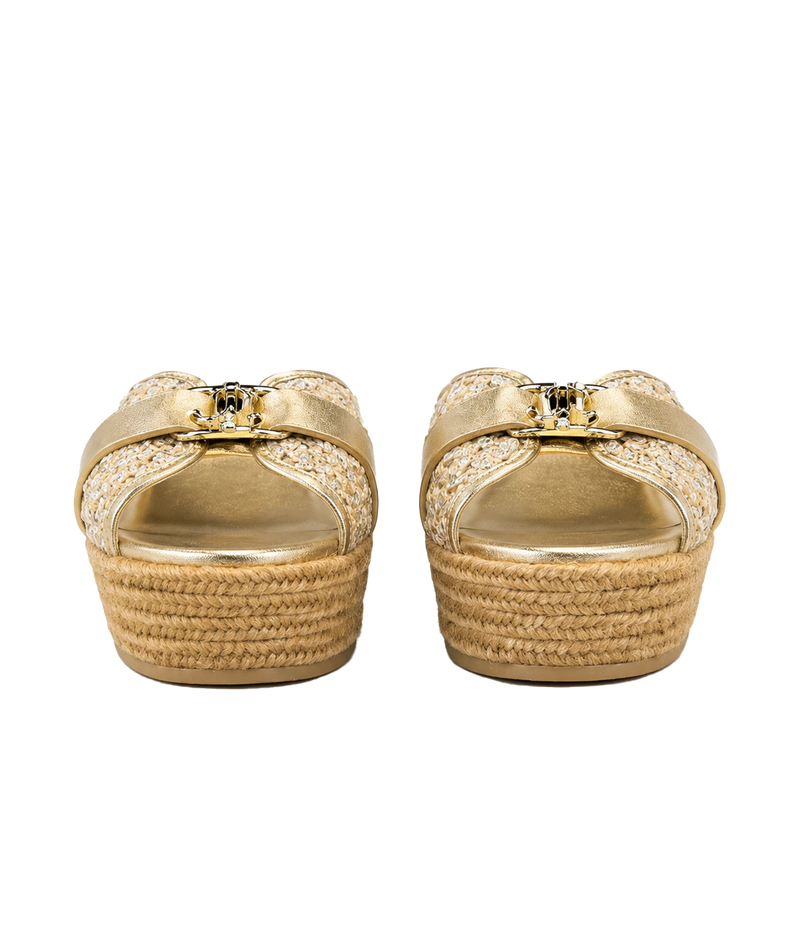 A pair of women's espadrille wedge sandals shown from the back, featuring a metallic gold buckle strap, a woven beige and gold upper, and a braided jute platform sole.