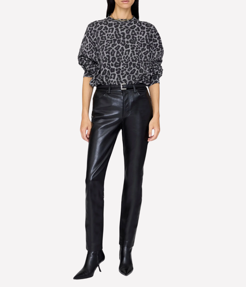 Person wearing a leopard print top and black leather pants on a white background