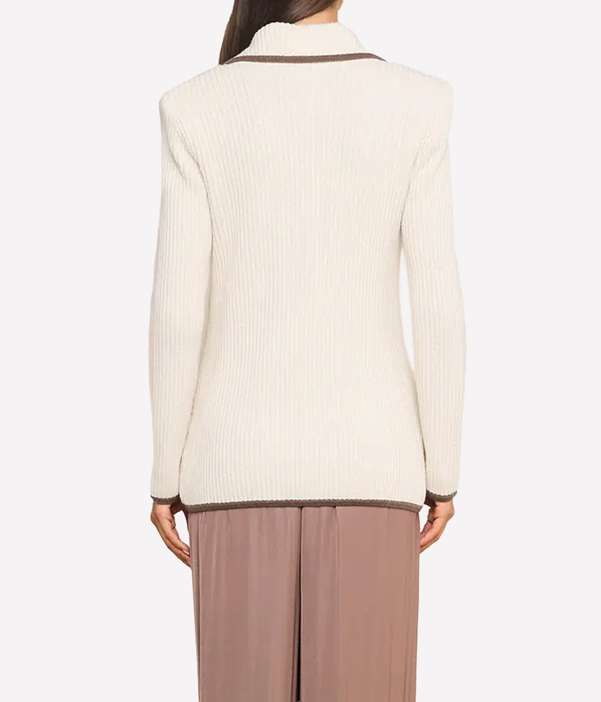 A woman wearing a cream ribbed knit blazer, back view.