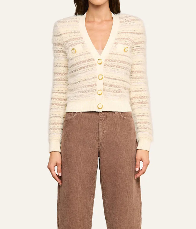A model wearing a cream-coloured textured knit cardigan with gold buttons and brown corduroy trousers, front view.