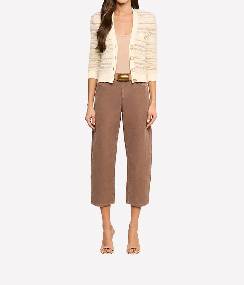 A model is shown from the neck down wearing a cream-coloured textured knit cardigan with gold buttons, a beige top, brown cropped wide-leg trousers with a gold belt, and nude heeled sandals.