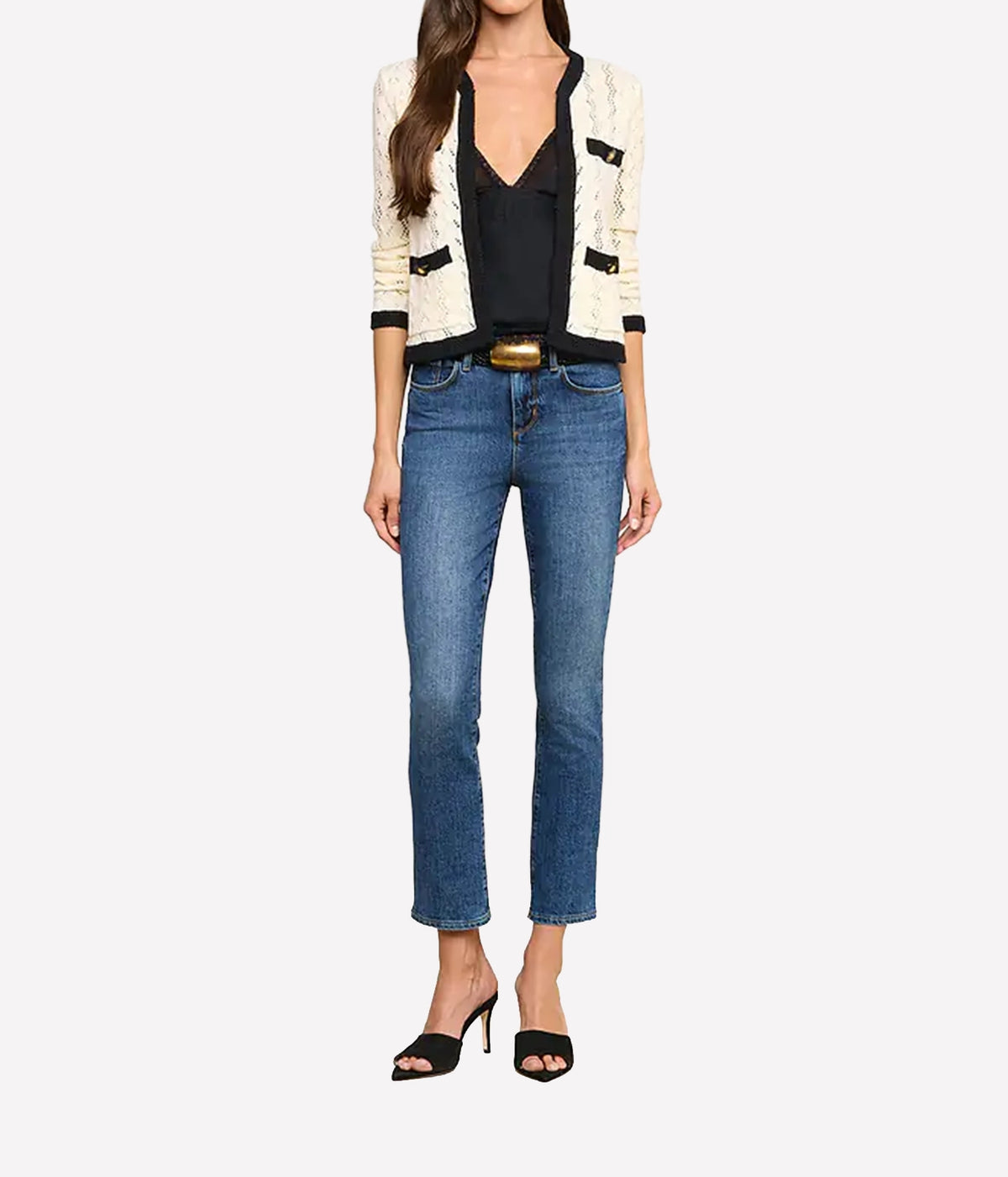 A model wearing the L'AGENCE Zephyra Pointelle Knit Cardigan in Ivory & Black, a black camisole, blue cropped jeans