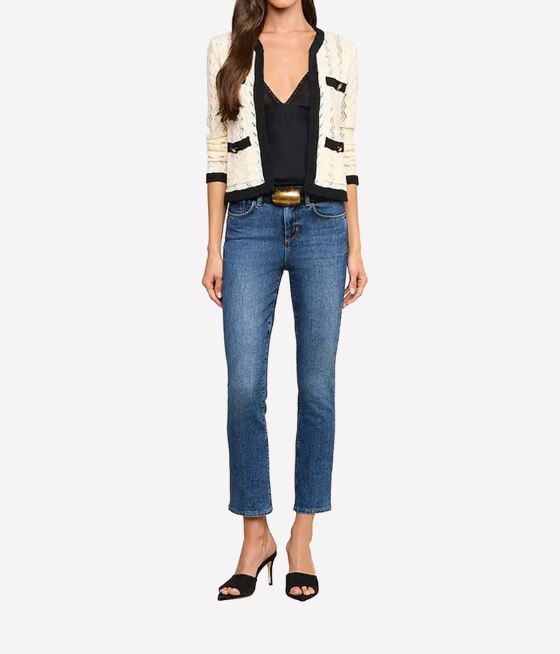 A model wearing the L'AGENCE Zephyra Pointelle Knit Cardigan in Ivory & Black, a black camisole, blue cropped jeans