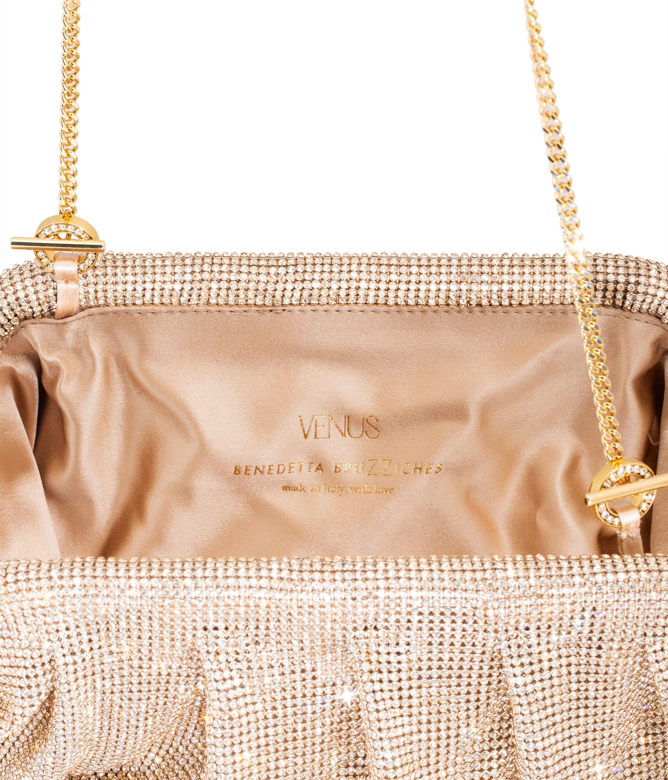 Close-up of a metallic champagne pink rhinestone clutch bag with a satin interior. 