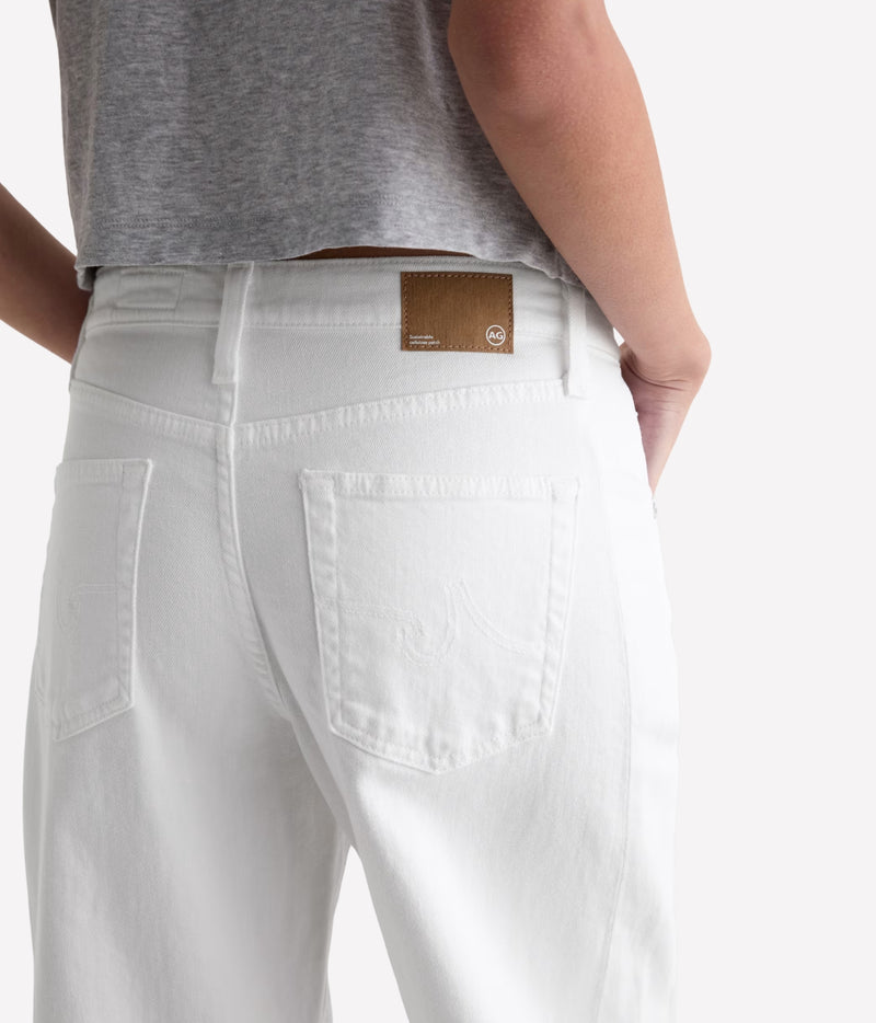 White denim jeans shown from the back on a model, featuring a brown leather brand patch on the waistband and a tonal embroidered logo on the back pocket.