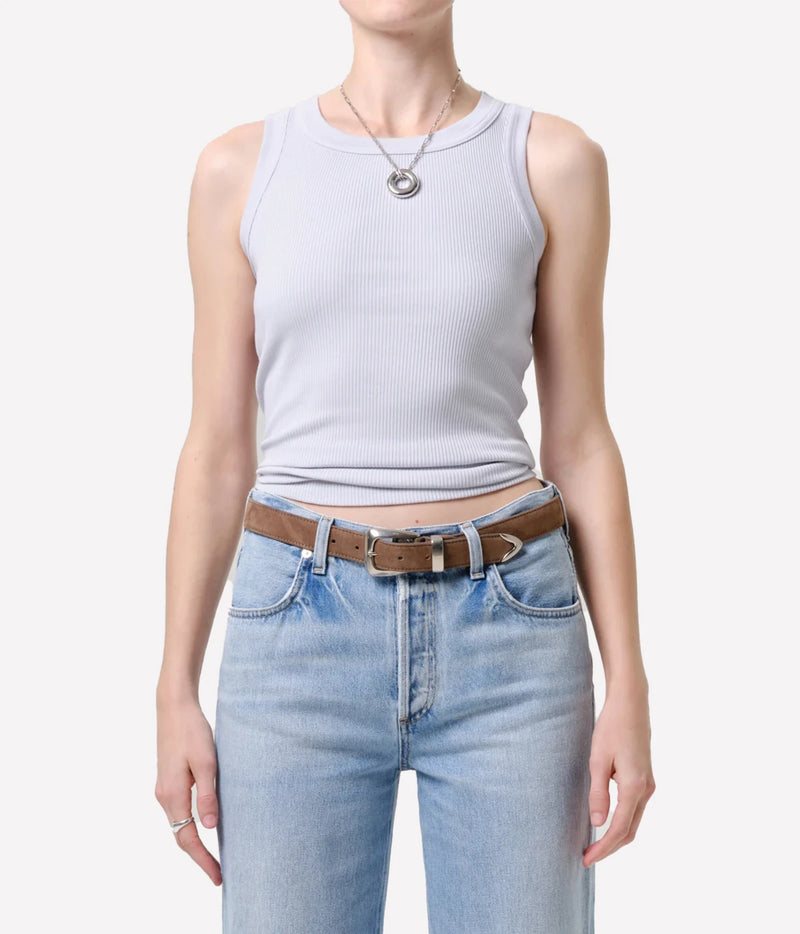 Front view of a model wearing the Citizens Of Humanity Isabel Rib Tank in Pindary, showing the round neckline and cropped length sitting just above light-wash jeans with a brown leather belt and silver pendant necklace