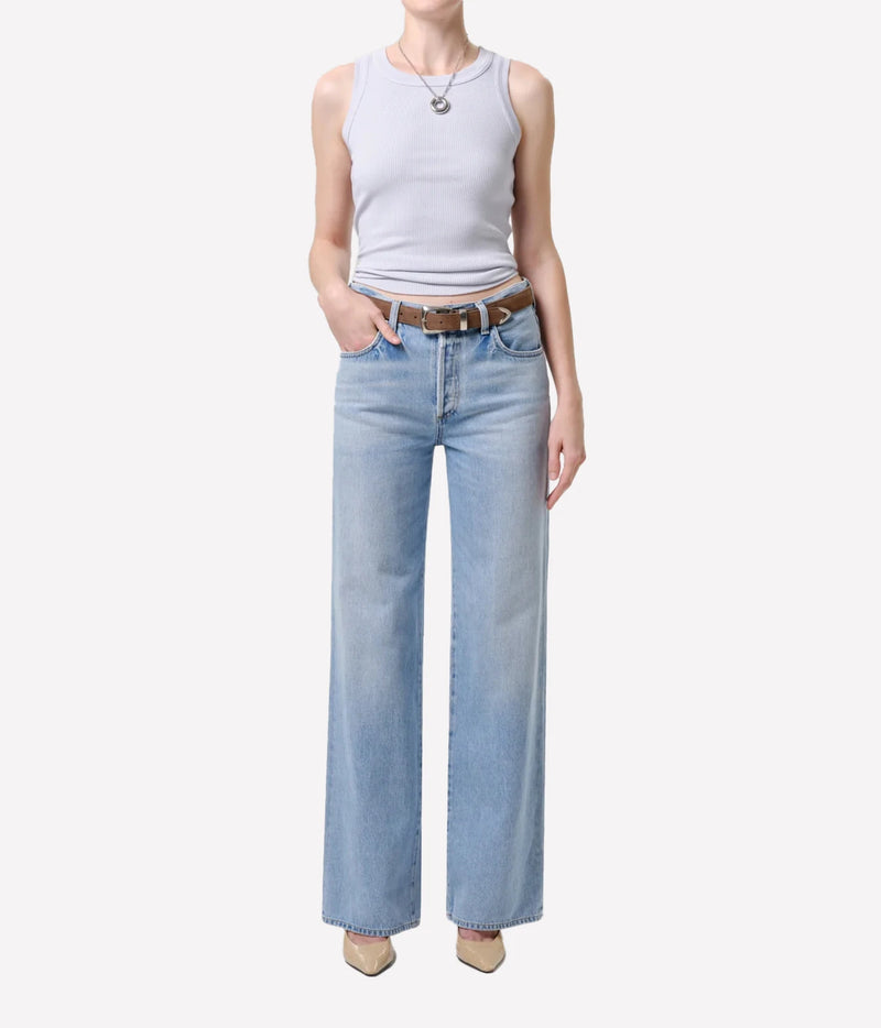 Full-length front view of a model wearing the Citizens Of Humanity Isabel Rib Tank in Pindary with light-wash wide-leg jeans, a brown leather belt, silver pendant necklace and nude heels