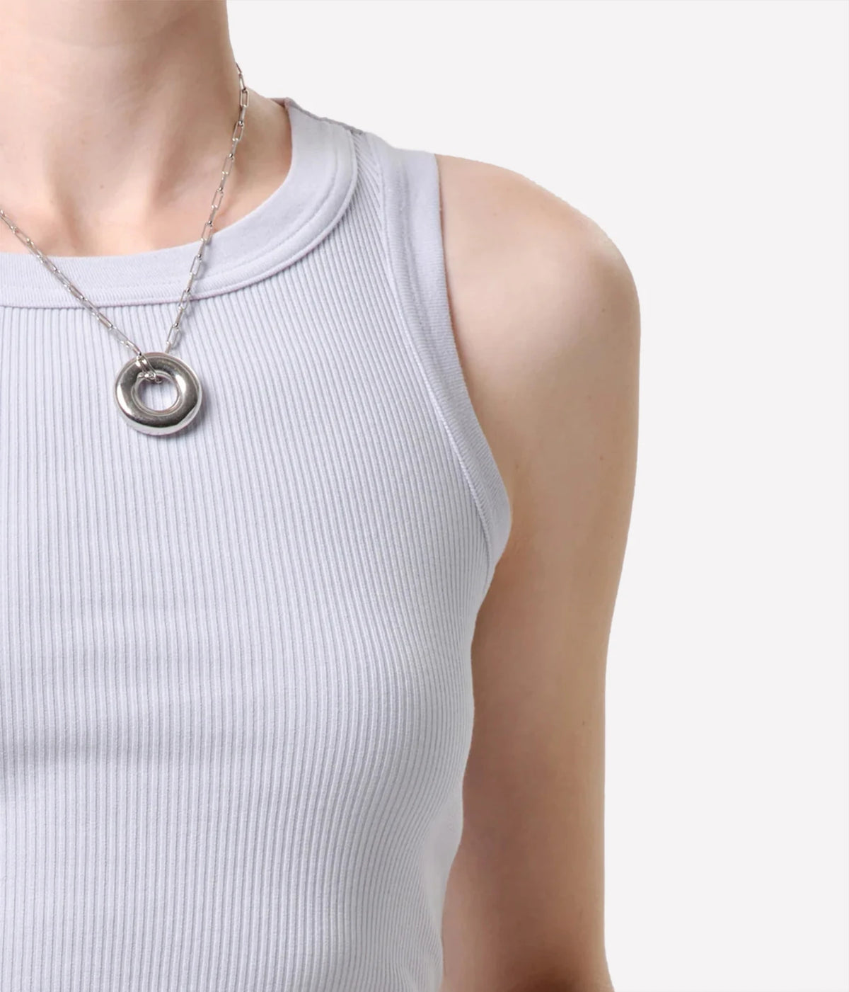 Close-up of the Citizens Of Humanity Isabel Rib Tank in Pindary, showing the fine rib knit, bound neckline and armhole, worn with a silver circle pendant necklace